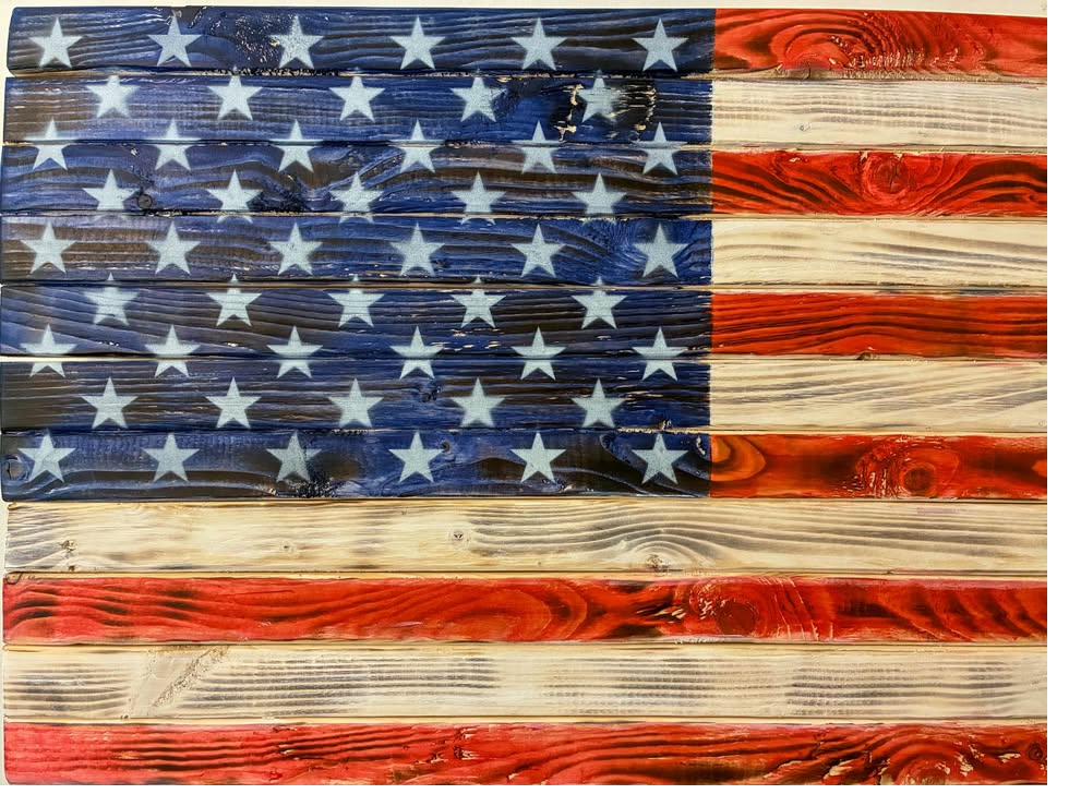 Handcrafted wood American flag with a torch-burnt charred finish highlighting deep red tones and natural wood grain